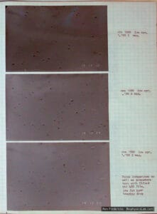 Lab notebook page with three photomicrographs of homogenized low-fat milk at 1,100×, fat globules showing as dark points, with handwritten film notes.